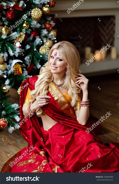 Very Beautiful Blonde Girl In Indian Red Saree Sitting On The Floor