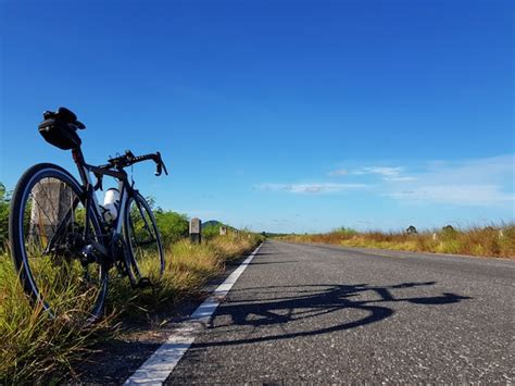 A bicicleta estacionou ao lado da estrada aberta céu azul conceito