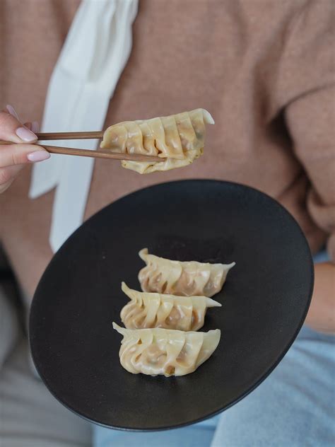 Woman Holding Dumplings with Chopsticks · Free Stock Photo