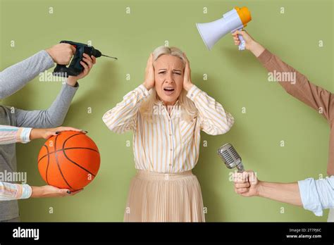 Mature Woman Suffering From Noisy Neighbours On Green Background Stock