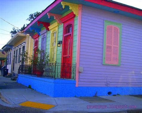 A Row Of Colorful Houses On The Side Of A Street With Cars Parked In Front