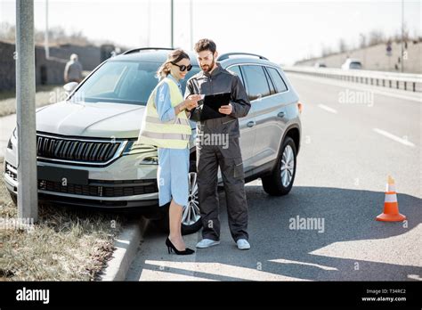 Woman With Road Assistance Worker Signing Some Documents Standing Near