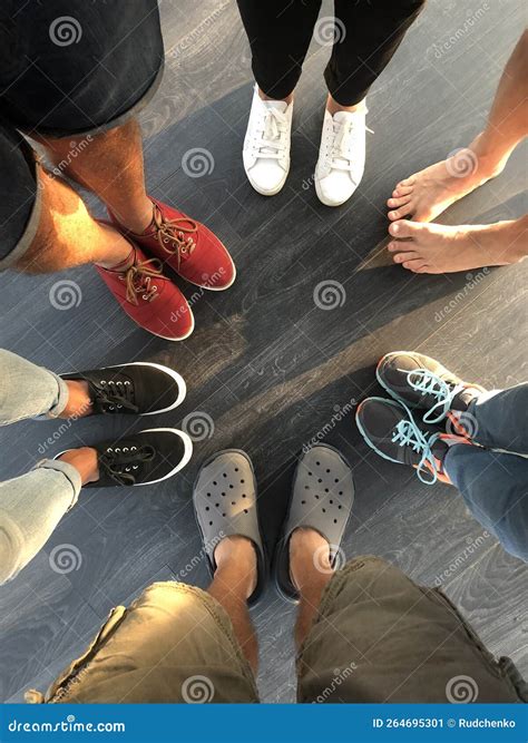 Group of Young People Feet Stand in a Circle. Five People in Shoes and