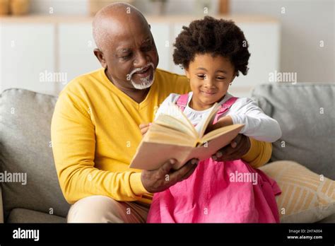 Cheerful Cute African American Little Granddaughter And Senior Grandpa