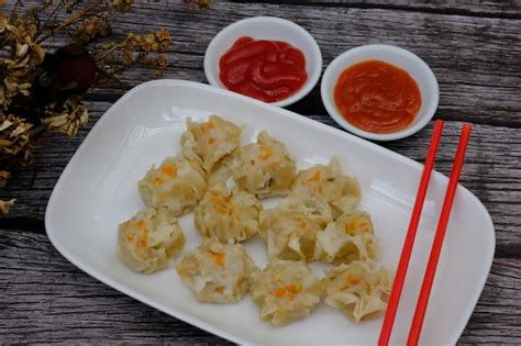 Premium Photo | Siomay on a white ceramic plate. tomato sauce. chili sauce. dim sum. shumai ...