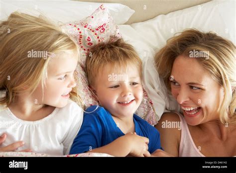 Mother And Children Relaxing Together In Bed Stock Photo Alamy