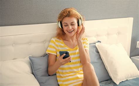 Glad Woman In Headphones Listen Music On Phone Woman At Home Listen To