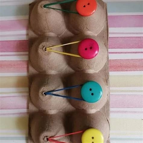 An Egg Carton Filled With Different Colored Buttons And Pins On Top Of