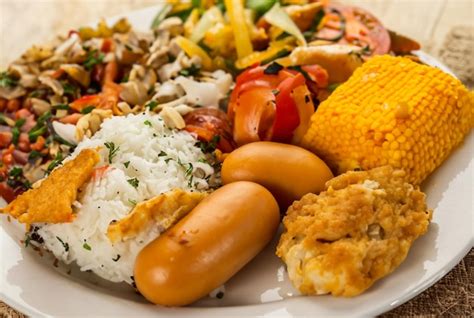 Um prato de comida incluindo camarão arroz e legumes Foto Premium