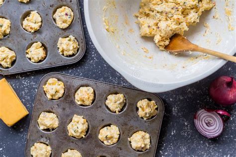 Cheddar Cheese And Herbs Mini Muffin Dough Uncooked Being Placed In