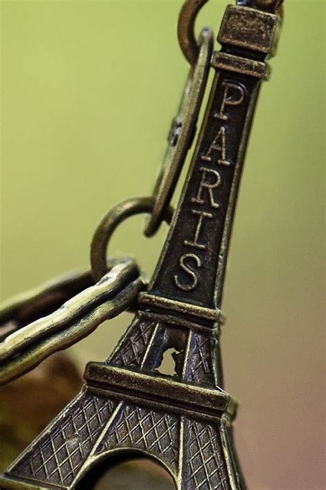 The Eiffel Tower Charm Is Sitting On Top Of A Piece Of Wood