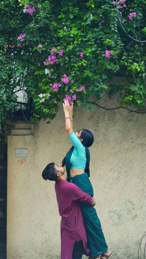 Two People Reaching Up Into The Air To Grab Something Out Of Their