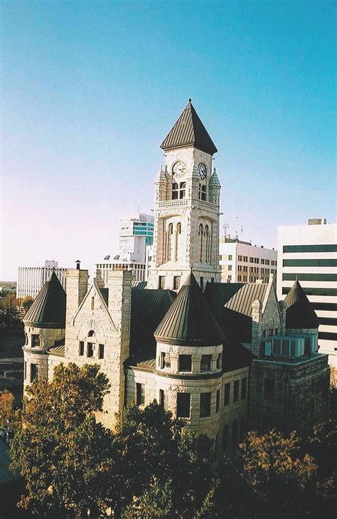 an old building with a clock tower in the middle of it's roof tops