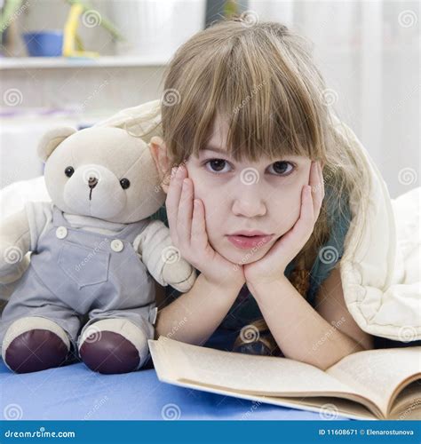 La Muchacha Que Lee Un Libro Que Miente En Cama Con Peluche Lleva