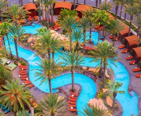 an aerial view of a resort pool surrounded by palm trees and lounge ...