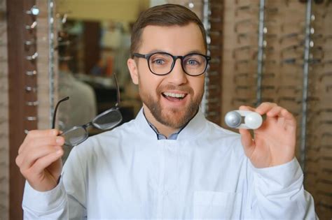 Oftalmólogo eligiendo entre anteojos y lentes de pie en el gabinete