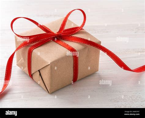 Gift Wrap Brown Kraft Paper With Red Ribbon On White Wooden Table