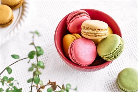 Premium Photo Colorful French Macarons In Pink Bowl On White Tablecloth