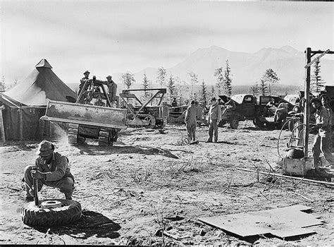 An Old Black And White Photo Of Men Working In The Dirt With Trucks