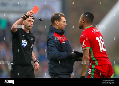 Swansea City's Jordan Ayew (right) is shown the red card by referee ...