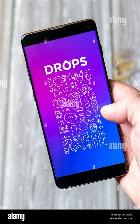 A Mobile Phone Or Cell Phone Being Held In A Hand Showing The Drops