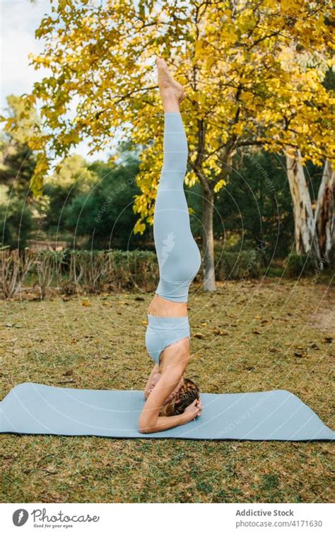 Woman In Supported Headstand Pose Doing Yoga In Park A Royalty Free