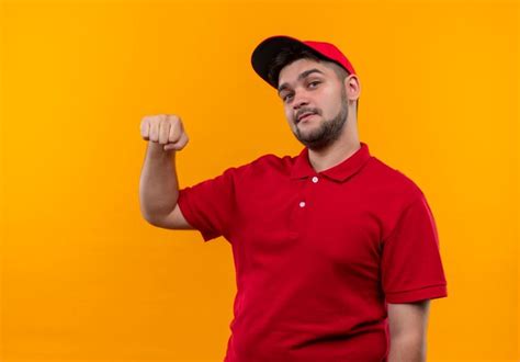 Jovem Entregador De Uniforme Vermelho E Bon Levantando O Punho