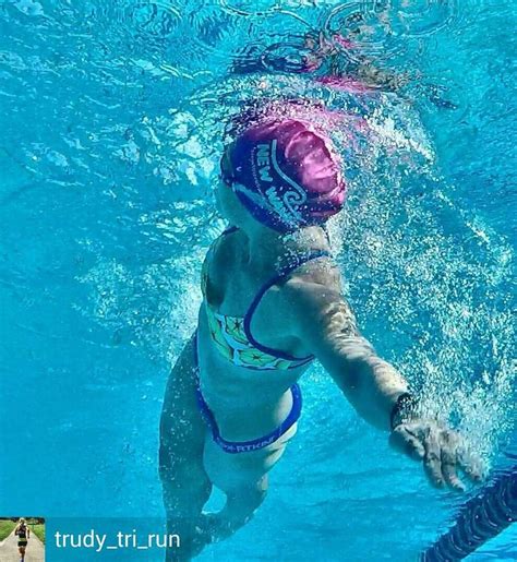 A Woman Swimming In A Pool Wearing A Pink Hat