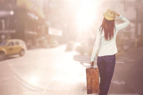 Premium Photo Rear View Of Hipster Woman Holding Suitcase Against