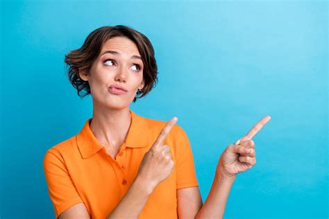 Photo Of Shiny Doubtful Lady Wear Orange Tshirt Pointing Two Fingers