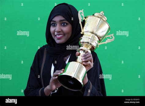 Dubai, United Arab Emirates, women in national costume holds a cup in ...