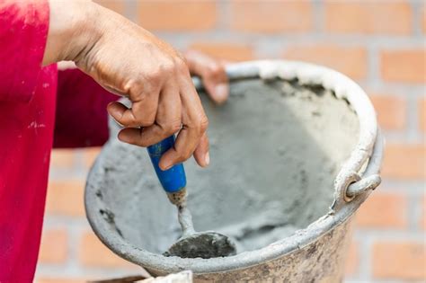 Premium Photo Close Up Hand Of Worker Holding Trowel And Bucket With