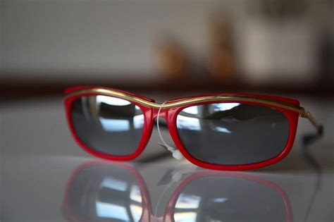 Red Cat Eye Frame With A Gold Metal Stripe Running Across The Forehead And Extending To Gold