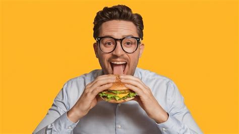 Premium Photo Funny Man In Glasses Eating Hamburger Isolated On A White