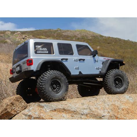 A Gray Jeep Parked On Top Of A Large Rock