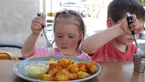 Two Little Kids Funny Eating Chicken Nuggets With Forks In Street Restaurant Stock Footage Video ...