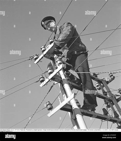 In The 1940s A Man Is Seen Climbing On Top Of An Electrical Pole With