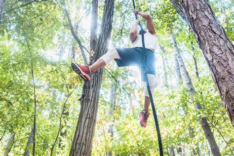 Fit Man Climbing Rope High Up In Stock Image Colourbox