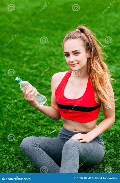 Mulher De Sorriso Bonita Que Relaxa Na Grama No Parque Durante O