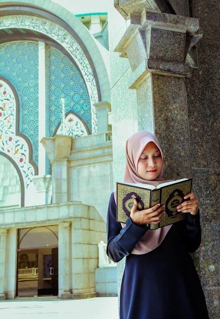 Premium Photo Young Woman Wearing Hijab While Reading Holy Book At Mosque