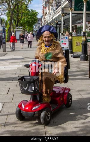 A Man Dressed In A Scarecrow Costume On Stilts Poses For A Picture With