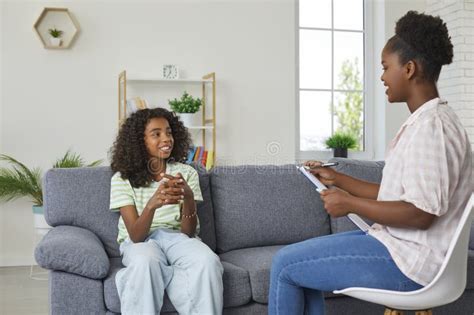 Happy African American Girl Sitting On Couch And Talking To Her