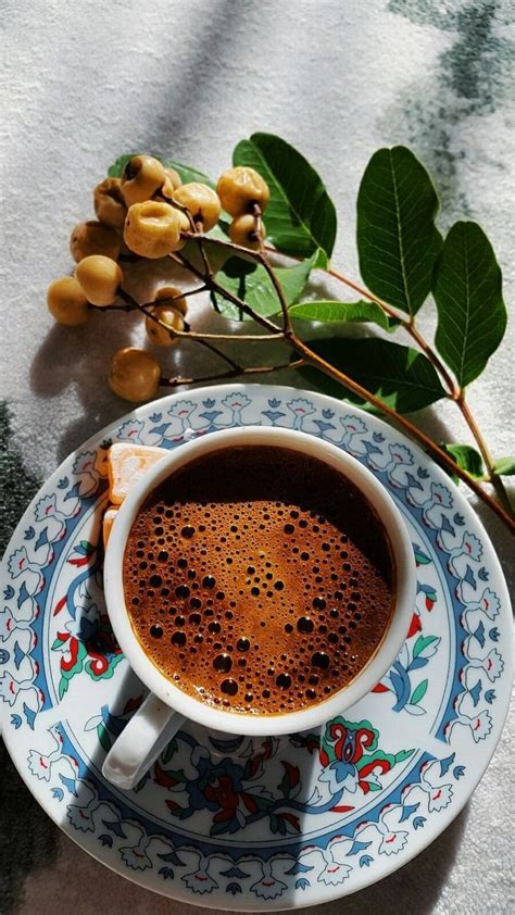 A Cup Of Coffee Sitting On Top Of A Blue And White Plate Next To A Plant