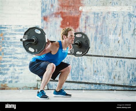 Caucasian Man Lifting Weights In Warehouse Stock Photo Alamy