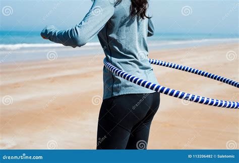 Muchacha Que Ejercita Con El Aro Del Hula En La Playa Foto De Archivo