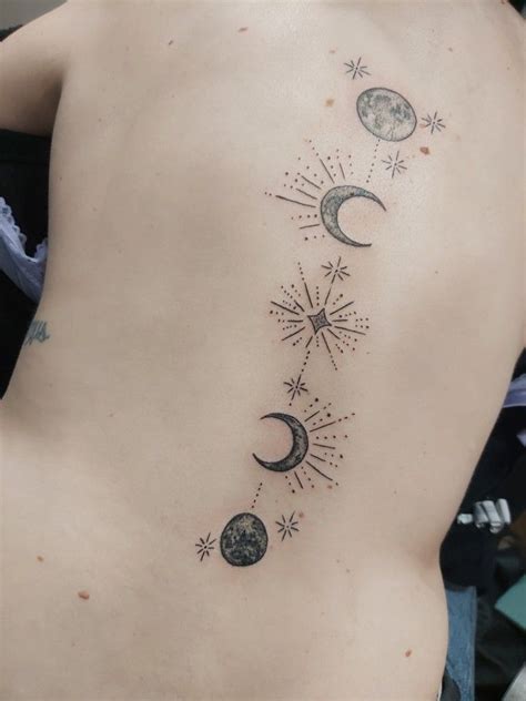 the back of a woman's stomach with stars and moon tattoos on her left side