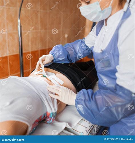 A Paramedic Puts On An Oxygen Mask On An Unconscious Woman Lying On A