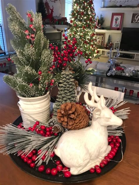 A Christmas Centerpiece With Pine Cones Evergreens And Deer Figurines