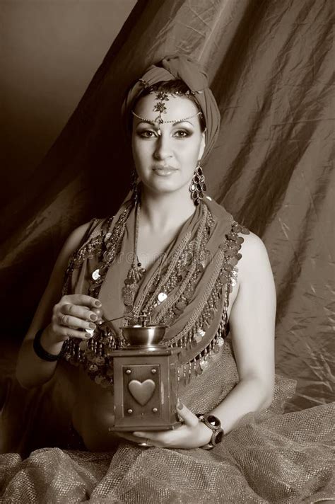 Schöne Brunette Frau in Der Roten Orientalischen Kleidung Mit Einem Turban Und Einem Schmuck Auf