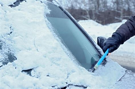 Premium Photo Removing Snow From Car Windshield Closeup